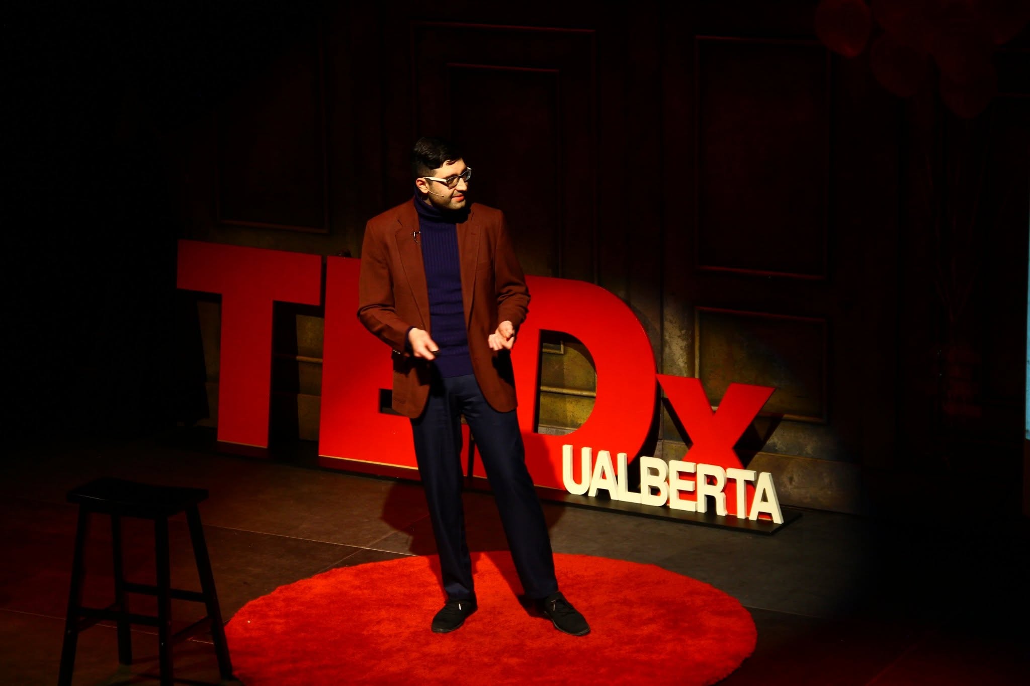 Saman Arfaie speaking on a TEDx stage